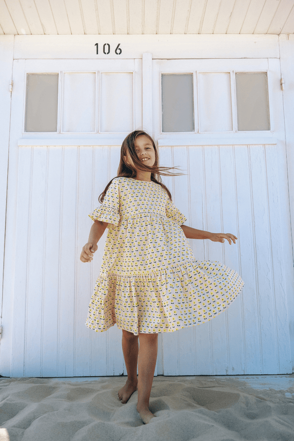 Fille portant la robe longue EDNA imprimé petites fleurs jaunes vêtements en coton bio certifié GOTS style vintage mixte unisexe